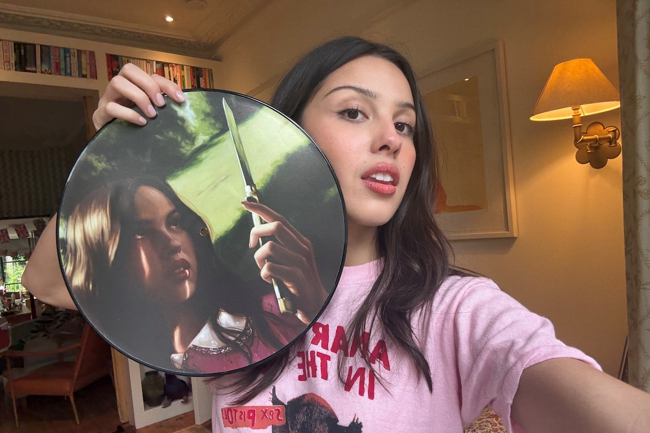 Olivia Rodrigo holding the “Carve Our Names” picture-disc edition