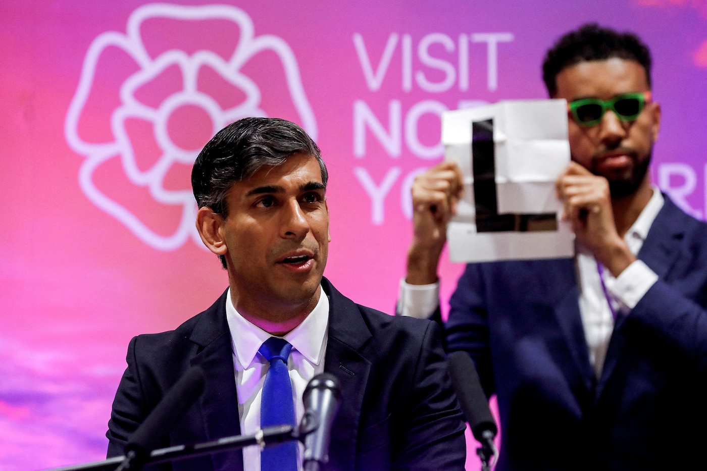 Niko Omilana holds an ‘L’ behind Rishi Sunak