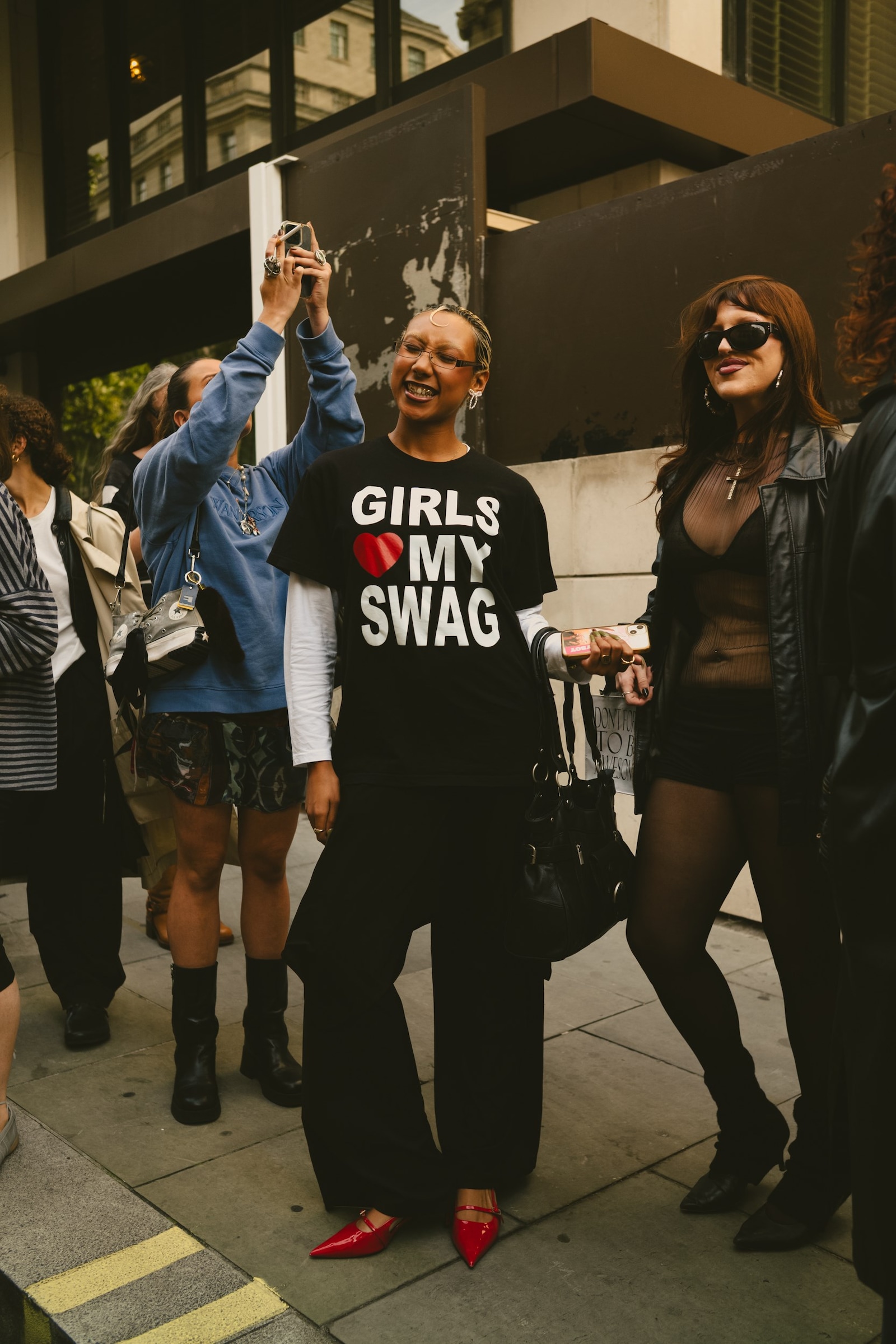 London Fashion Week street style featuring a bold text slogan T-shirt