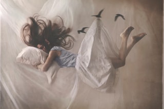 A sleeping woman floats in her room